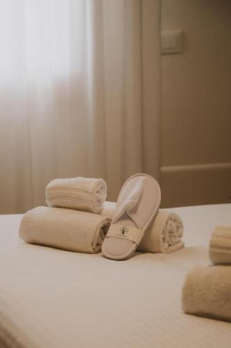 a pile of towels and slippers on a bed at Tursport in Taranto