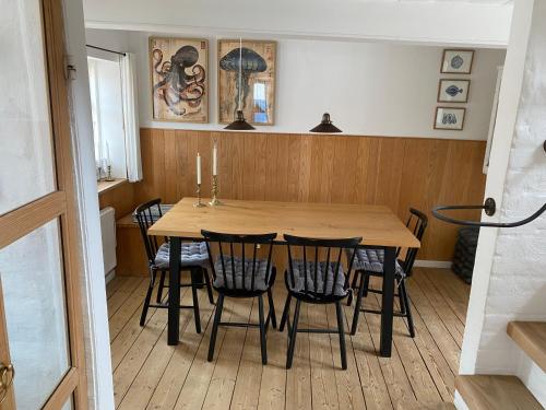 a dining room with a wooden table and chairs at Byhus Bogense in Bogense