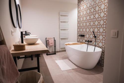a bathroom with a large tub and a sink at De Viervoeters Hoeve in Ruiselede