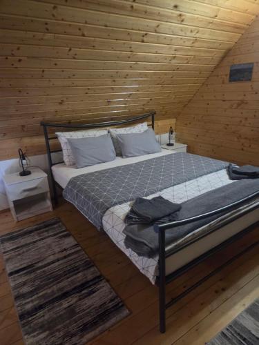 a bedroom with a bed in a wooden cabin at Brvnara K2 KONAK in Šljivovica