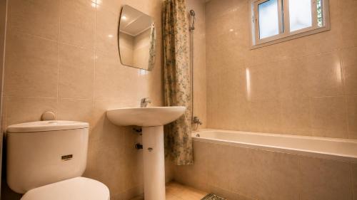 a bathroom with a toilet and a sink and a tub at Villa de charme in Ivato