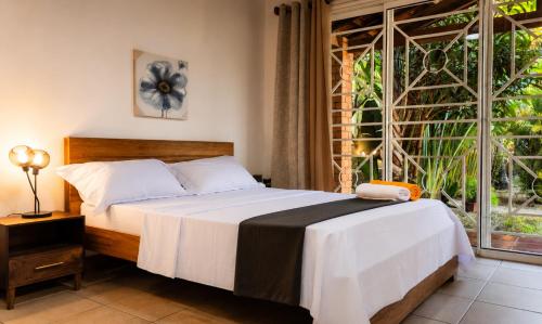 a bedroom with a bed and a large window at Villa de charme in Ivato