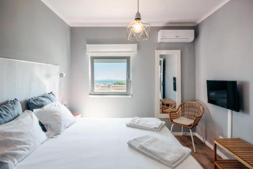 a white bedroom with a bed and a chair at Lagos Uptown Bed & Breakfast in Lagos