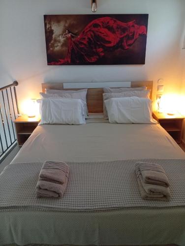 a bedroom with a large white bed with towels on it at Studio Mare in Nea Kallikrateia