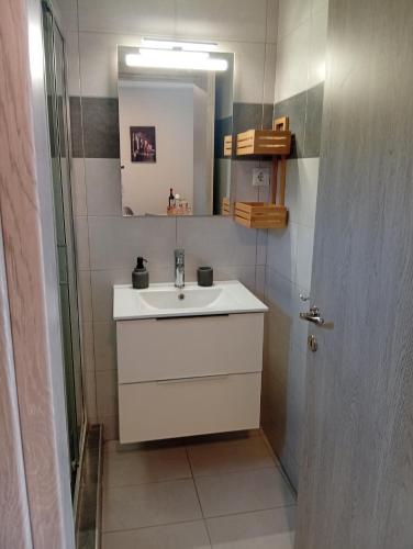 a bathroom with a sink and a mirror and a door at Studio Mare in Nea Kallikrateia