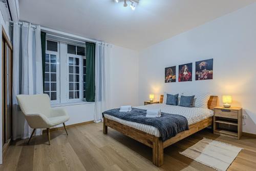 a bedroom with a bed and a chair and a window at GuestReady - Doctor House in Horta