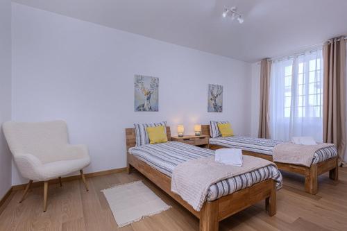 a bedroom with two beds and a chair and a window at GuestReady - Doctor House in Horta
