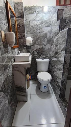 a bathroom with a toilet and a sink at Hostal Fragata Puerto López in Puerto López