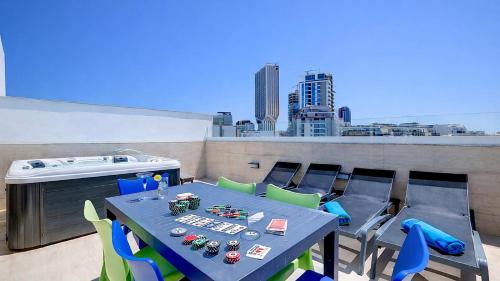 a table and chairs on a balcony with a hot tub at Bayside A Apartments in St. Julianʼs