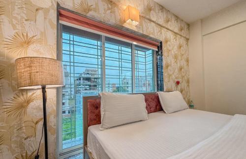 a bedroom with a bed and a large window at The Botanika Suites in New Town