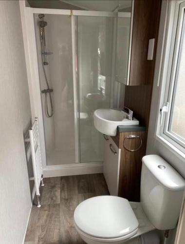 a bathroom with a shower and a toilet and a sink at SimpleStayHolland in Westerland
