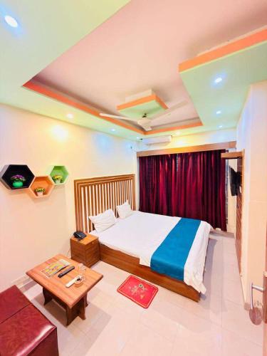 a bedroom with a bed and a table and a couch at Hotel Impulse Ocean View in Cox's Bazar