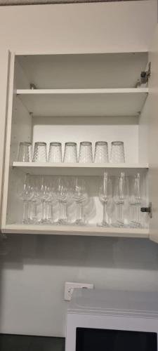 a shelf filled with glasses and wine glasses at Sofia Apartment - Aare Jungfrau AG in Wilderswil