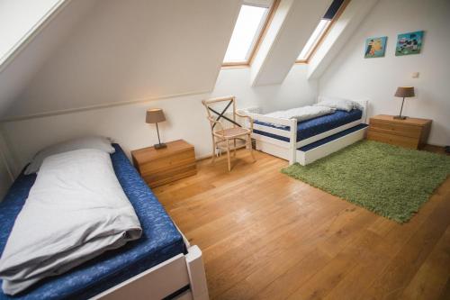 a attic bedroom with a bed and a chair at Weidevilla 14 auf Ameland in Hollum