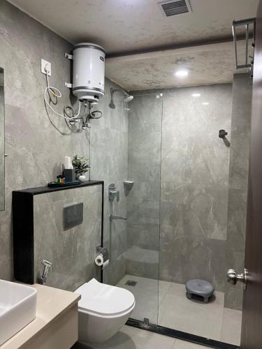 a bathroom with a toilet and a glass shower at The Barrel House, Varanasi in Varanasi