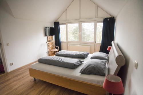 a bed with four pillows on it in a room at Weidevilla 16 in Hollum