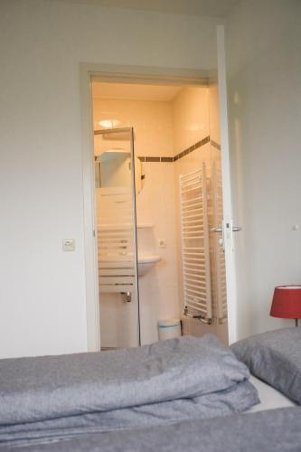 a small bedroom with a bed and a closet at Weidevilla 16 in Hollum