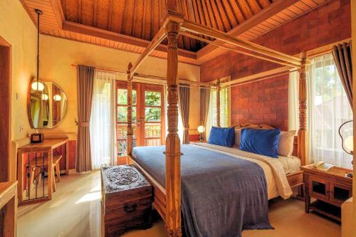 a bedroom with a canopy bed in a room at Rama Phala Resort & Spa in Ubud
