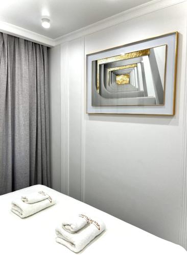 a room with a bed with a mirror and towels at Juldyz in Zharkent