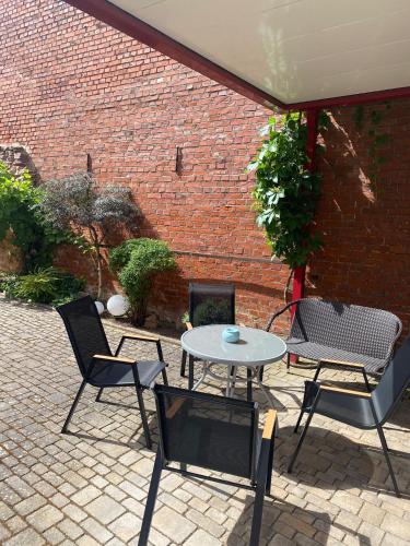 a patio with a table and chairs and a brick wall at Ferienwohnung am Oechsenberg in Unterbreizbach
