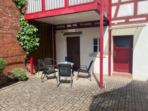 a patio with chairs and a table in front of a building at Ferienwohnung am Oechsenberg in Unterbreizbach