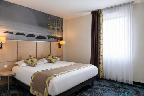une chambre d'hôtel avec un grand lit et une fenêtre dans l'établissement The Originals Boutique, Actuel Hôtel, Saint-Etienne Aéroport, à Andrézieux-Bouthéon
