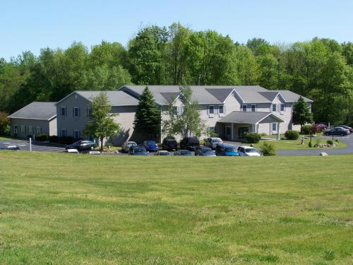 a group of houses with cars parked in a parking lot at Brook Pointe Resort in Syracuse