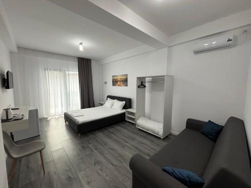 a living room with a bed and a couch at Vila SEA VIBES in Eforie Sud