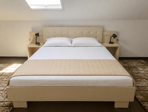 a bedroom with a large bed with two night stands at Vila Rin in Mangalia
