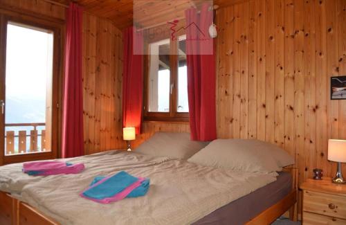 a bedroom with a bed with two towels on it at Chalet Zou Derri 3 in Les Collons