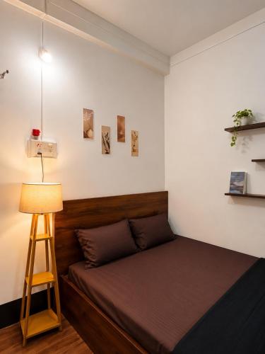 a small bedroom with a bed and a lamp at The Quiet Lantern Homestay in Sibsāgar