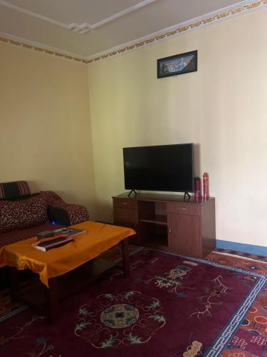 a living room with a couch and a flat screen tv at Lama home in Bālāju