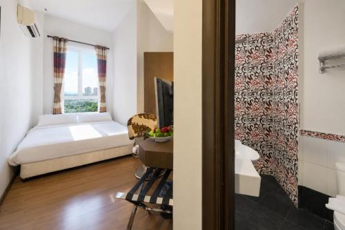 a bedroom with a bed and a tv in a room at Triima Inn Arenaa Melaka in Malacca