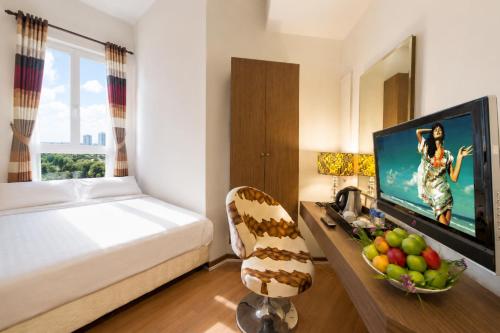 a hotel room with a bed and a television at Triima Inn Arenaa Melaka in Malacca