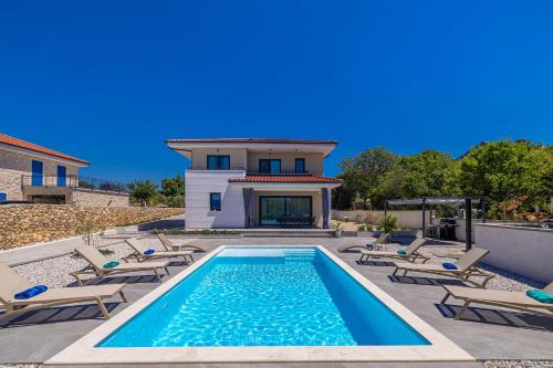 a swimming pool with chairs and a house at Villa ADRIA MOMENTS with private pool in Pinezici