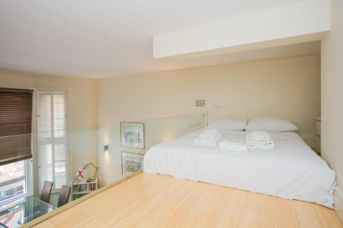a bedroom with a white bed and a wooden floor at Modern 1 bed Flat in Knightsbridge in London