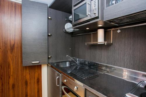 a kitchen with a sink and a stove at Modern 1 bed Flat in Knightsbridge in London