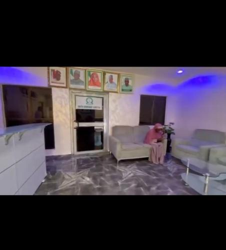 a person sitting on a couch in a living room at NBTE Hotels in Kaduna