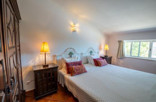 a bedroom with a bed with two pillows on it at Monte da Bravura Green Resort in Bensafrim