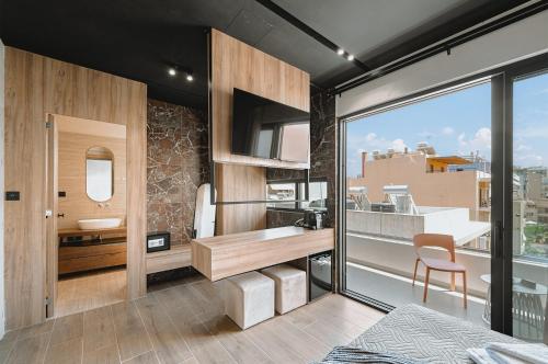 a bathroom with a sink and a desk with a window at MAHA Her City Living by Semavί in Heraklio