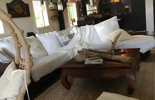a living room with a white couch and a table at Havre de paix in Péreuil