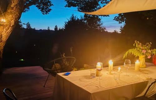 a white table with candles and a vase of flowers at Havre de paix in Péreuil