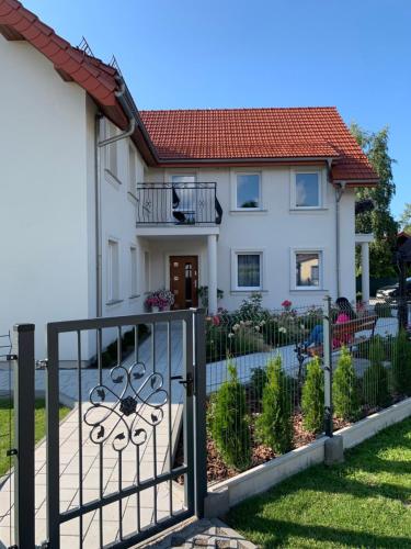 a house with a gate in front of it at Willa Róż in Rusinowo