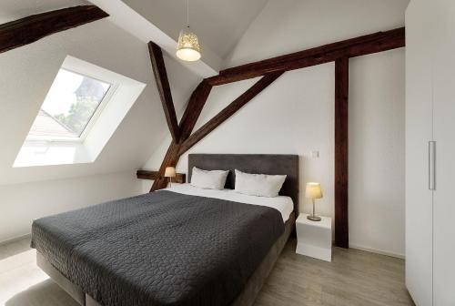 a bedroom with a large bed in a attic at Kenzingen Appartements zur Alten Brauerei in Kenzingen