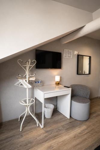 ein weißer Schreibtisch und ein Stuhl in einem Zimmer in der Unterkunft Hotel Bristol in Luxemburg (Stadt)