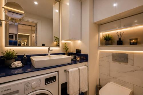 a bathroom with a sink and a washing machine at Seaside Studio at Orbi City in Batumi