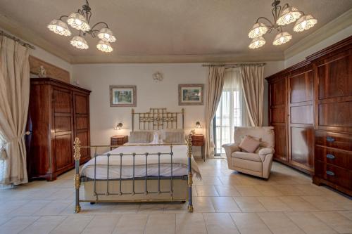 a bedroom with a bed and a couch and a chair at Valleyside Heights Residence - Pool & Heated Jacuzzi in Is-Swieqi