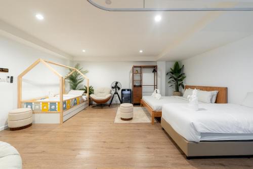 a bedroom with two beds and a crib at Nidhra Lanna Hotel Chiang Mai in Chiang Mai