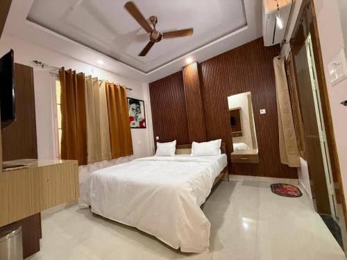 a bedroom with a large bed with a ceiling fan at Hotel Pravas Inn in Lucknow