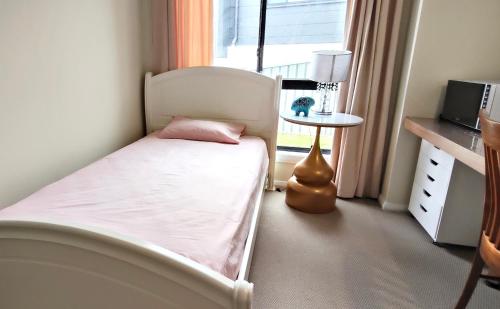 a small bedroom with a bed and a window at A private room with lounge room in Unanderra